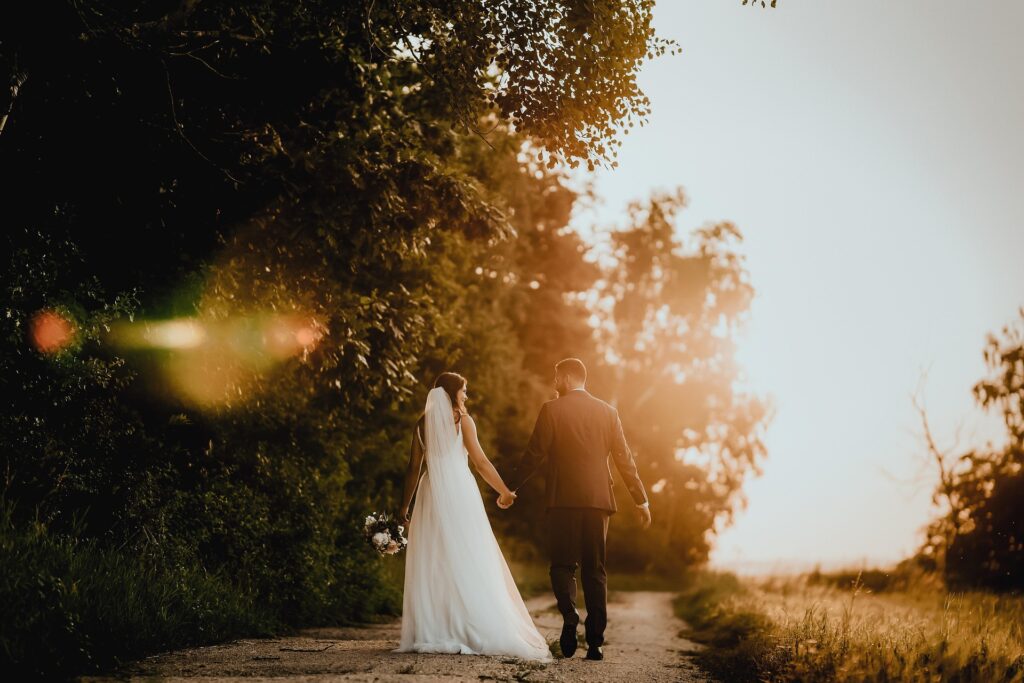 Hochzeitspaar bei warmem Abendlicht auf einem Weg